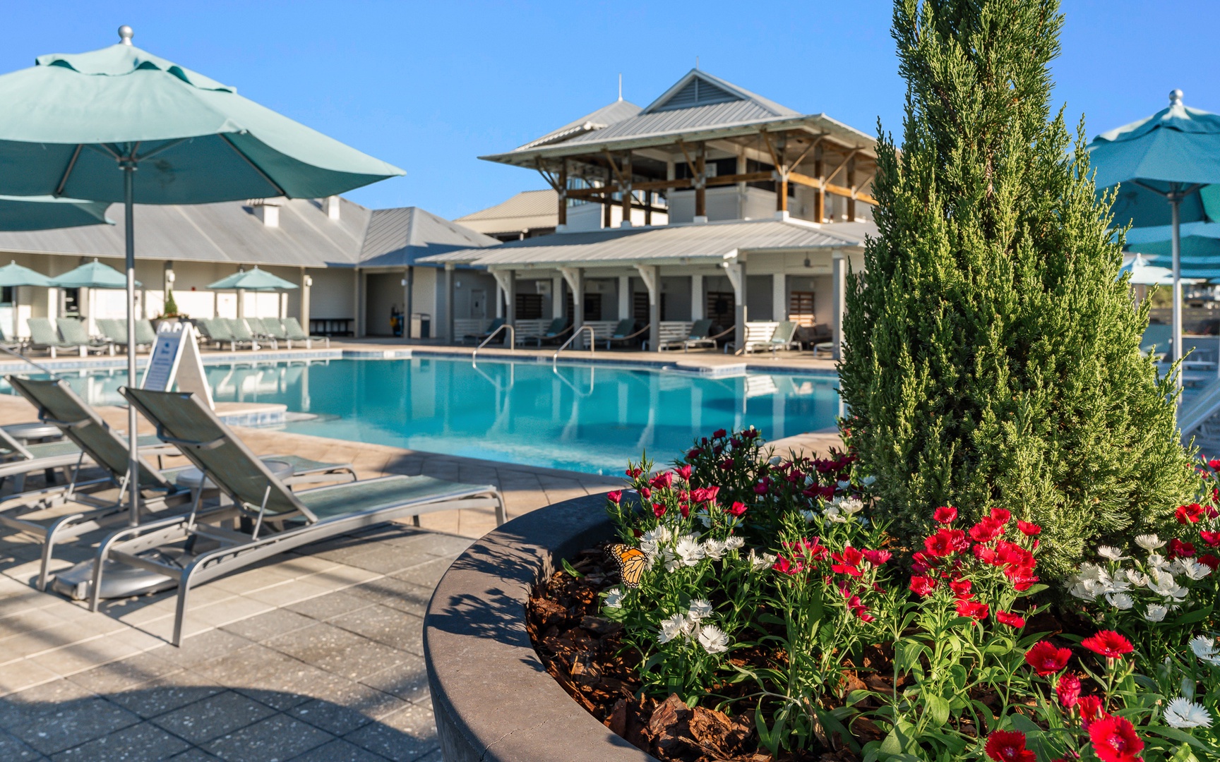 Sparkling pool surrounded by colorful gardens and comfortable loungers creates your perfect sunny retreat.