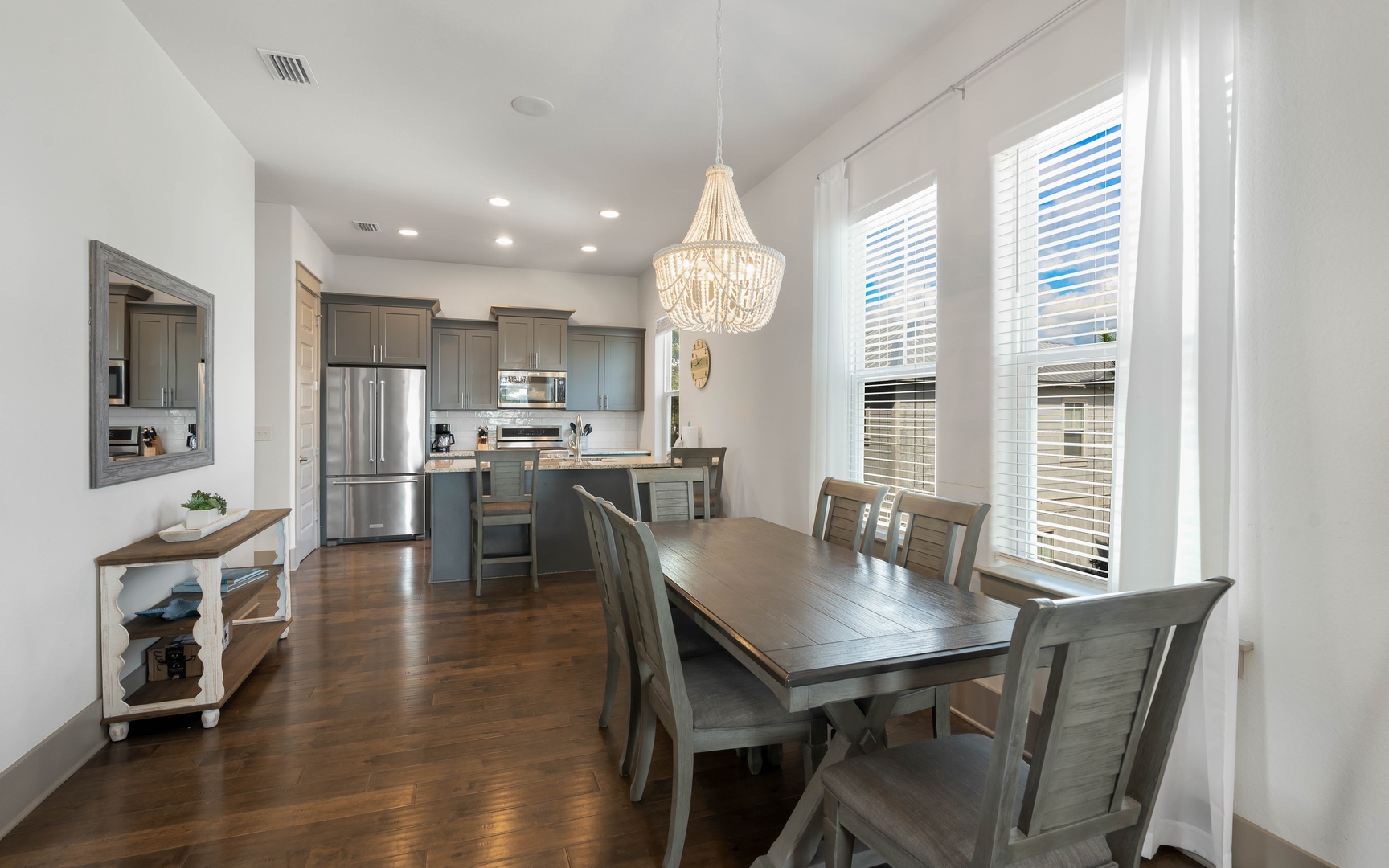 Gather around your stylish dining table where warm wood meets coastal charm, creating the perfect spot for memorable meals together.