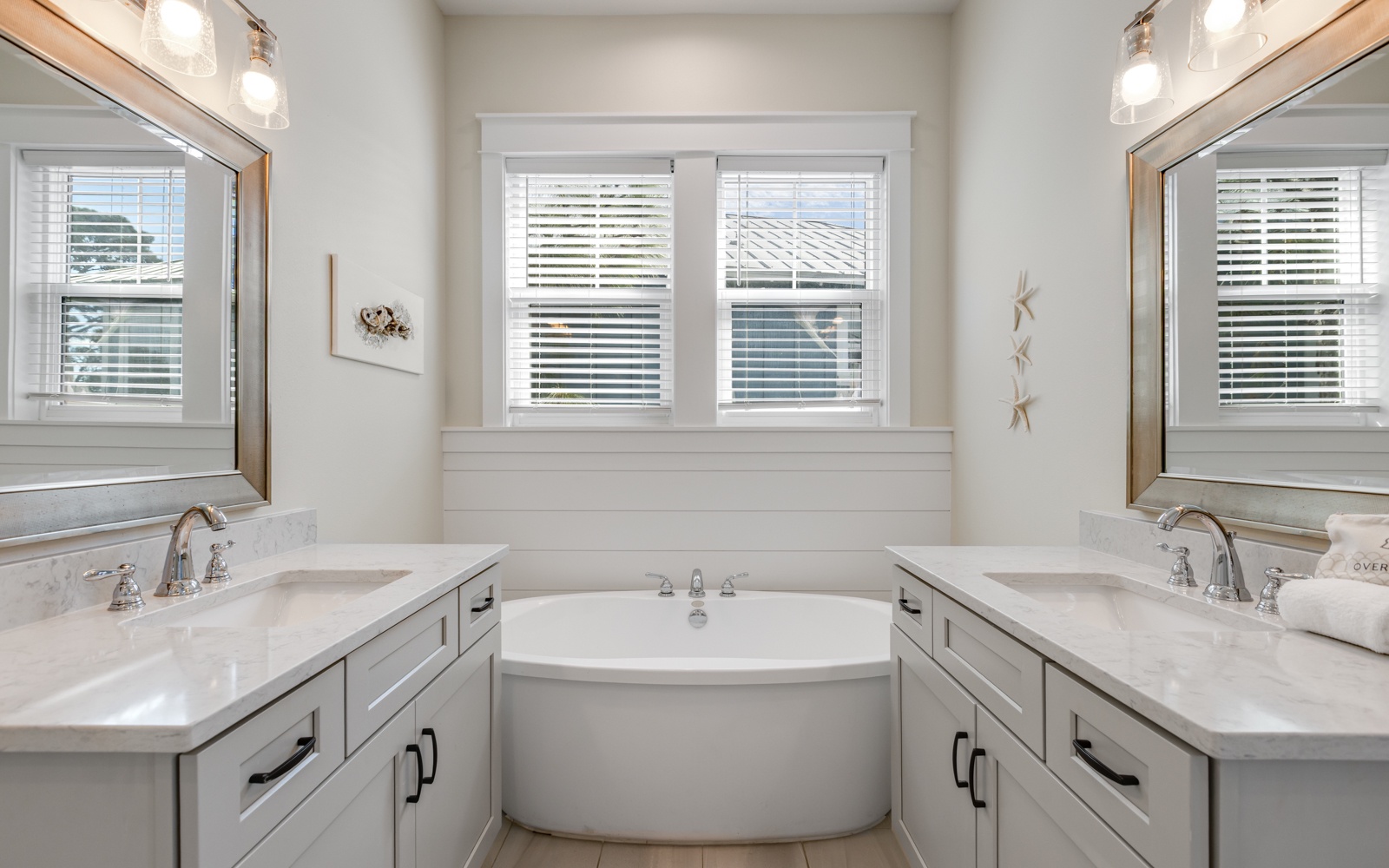 Unwind in your luxurious master bathroom featuring dual vanities, elegant marble countertops, and a relaxing soaking tub for peaceful evening retreats.
