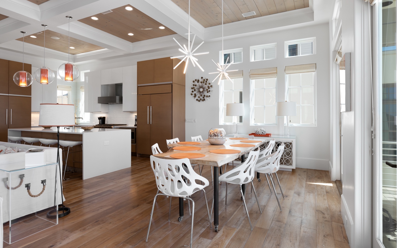 Gather around this stunning modern dining table where memorable meals unfold beneath elegant pendant lighting and soaring coffered ceilings.