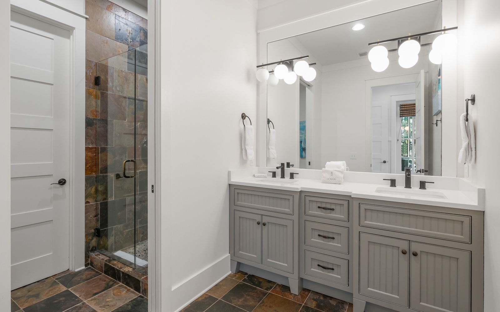 Your private bathroom features elegant stone flooring, spacious vanity, and a beautiful slate-tiled shower for ultimate relaxation.
