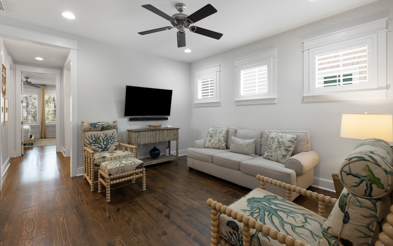 Your bright living room features coastal-inspired seating, flat-screen TV, and ceiling fan for perfect relaxation after beach days.
