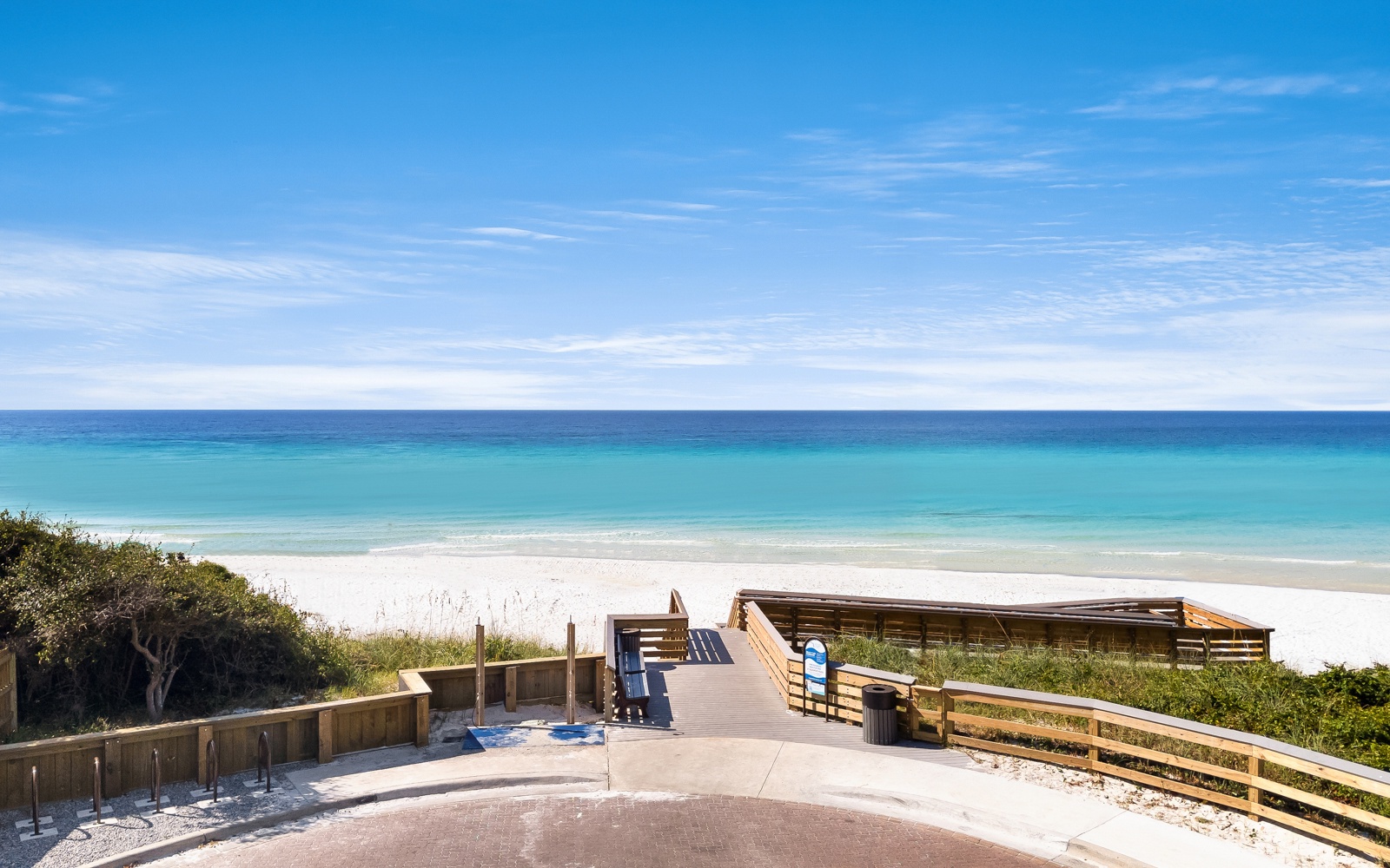 Pristine white sand beach with crystal-clear turquoise waters and convenient boardwalk access for easy arrival.