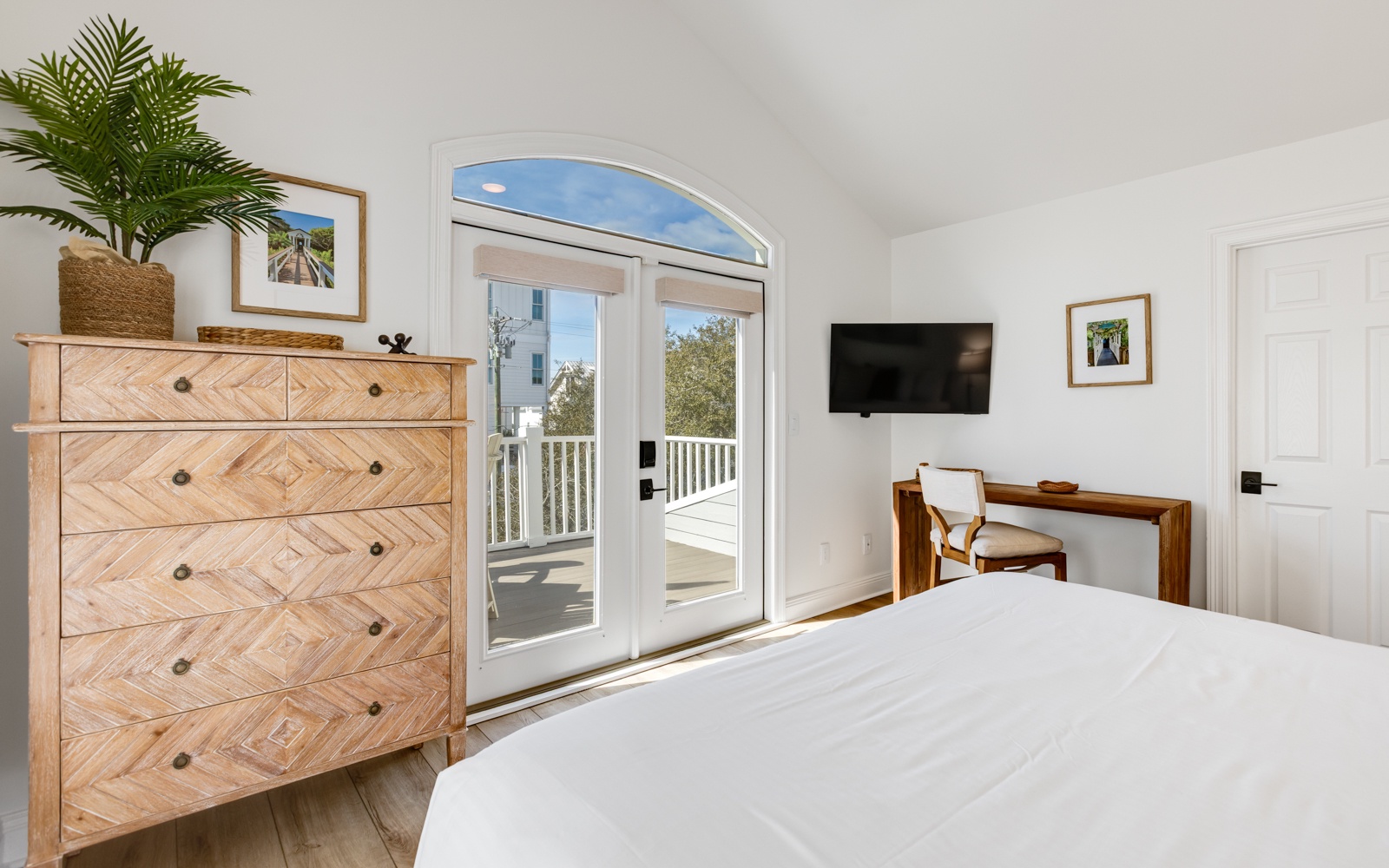 Step into your serene bedroom with elegant wood furnishings and French doors opening to your private balcony.