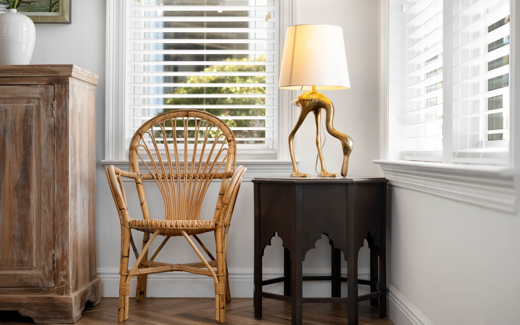Settle into your cozy reading nook with a charming wicker chair and warm lamp, where afternoon light filters through plantation shutters.