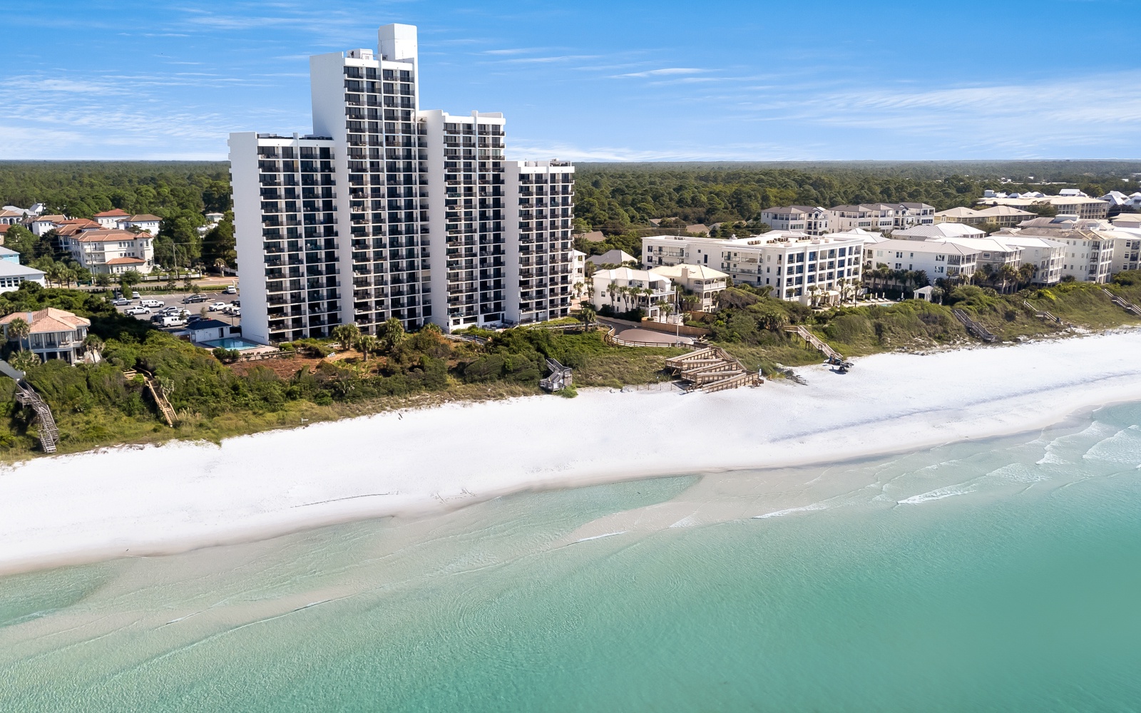 Stunning beachfront towers rise above pristine white sand and turquoise waters, offering an idyllic coastal retreat.