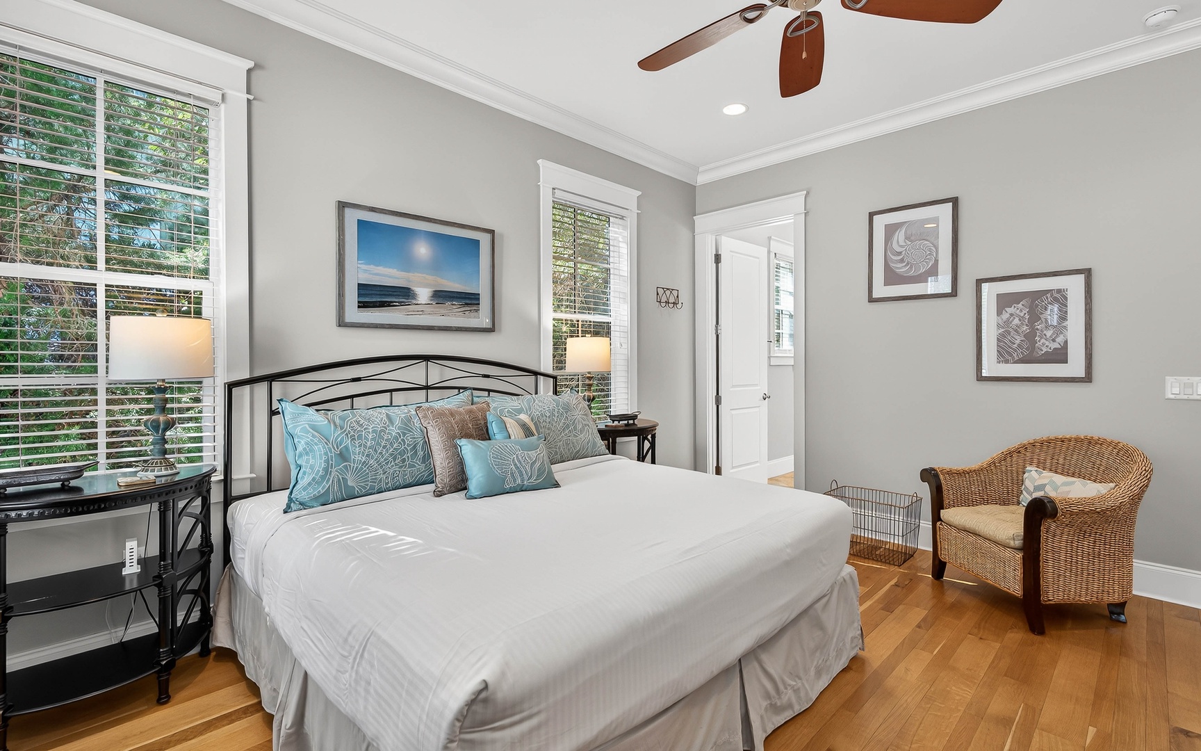 Drift off in this serene bedroom with soft coastal hues, warm hardwood floors, and gentle breezes from your ceiling fan overhead.