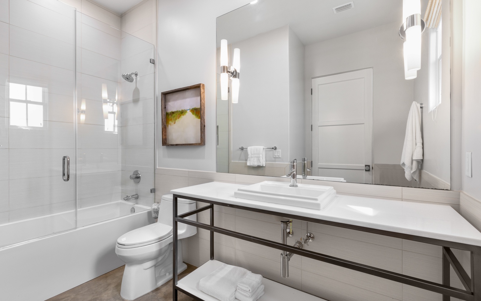 Unwind in your sleek bathroom with modern finishes, a glass-enclosed tub, and elegant lighting that creates the perfect spa-like retreat.