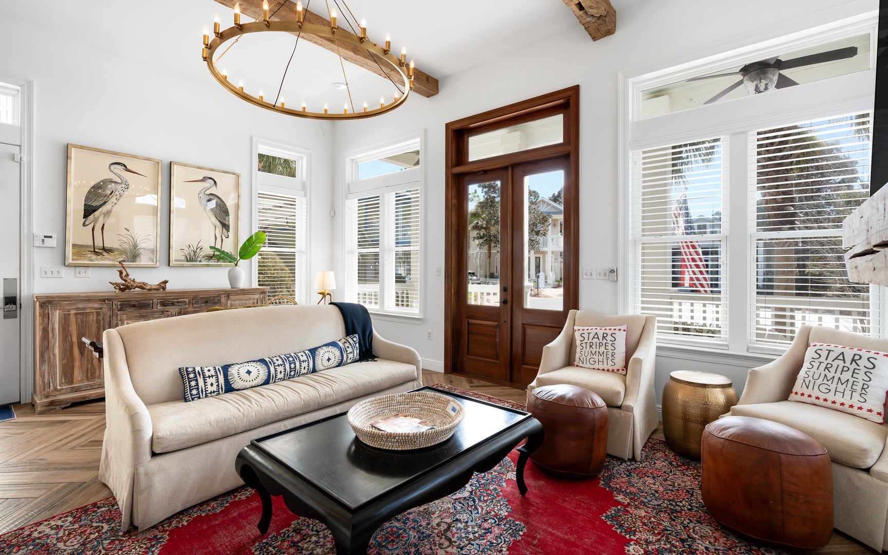 Unwind in your elegant living space with rustic beams, cozy seating, and charming coastal artwork creating the perfect retreat atmosphere.