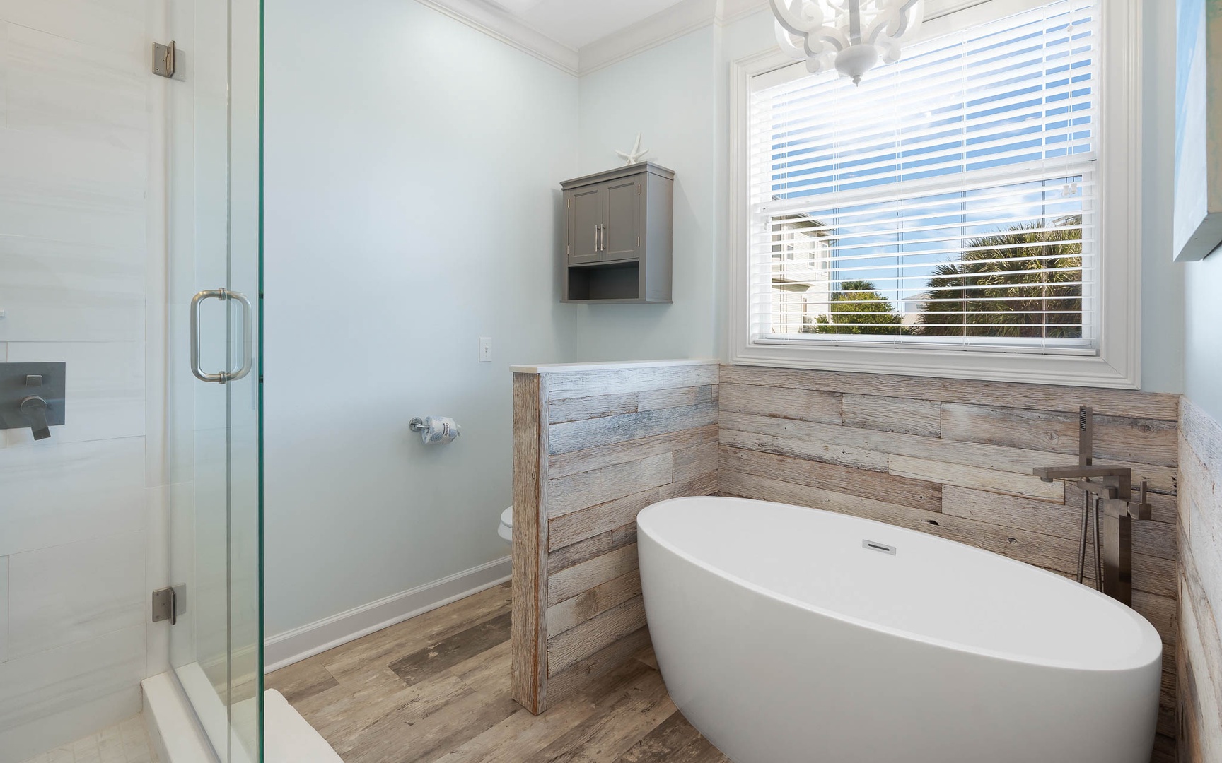 Soak in your elegant freestanding tub surrounded by rustic wood accents and natural light streaming through the window.