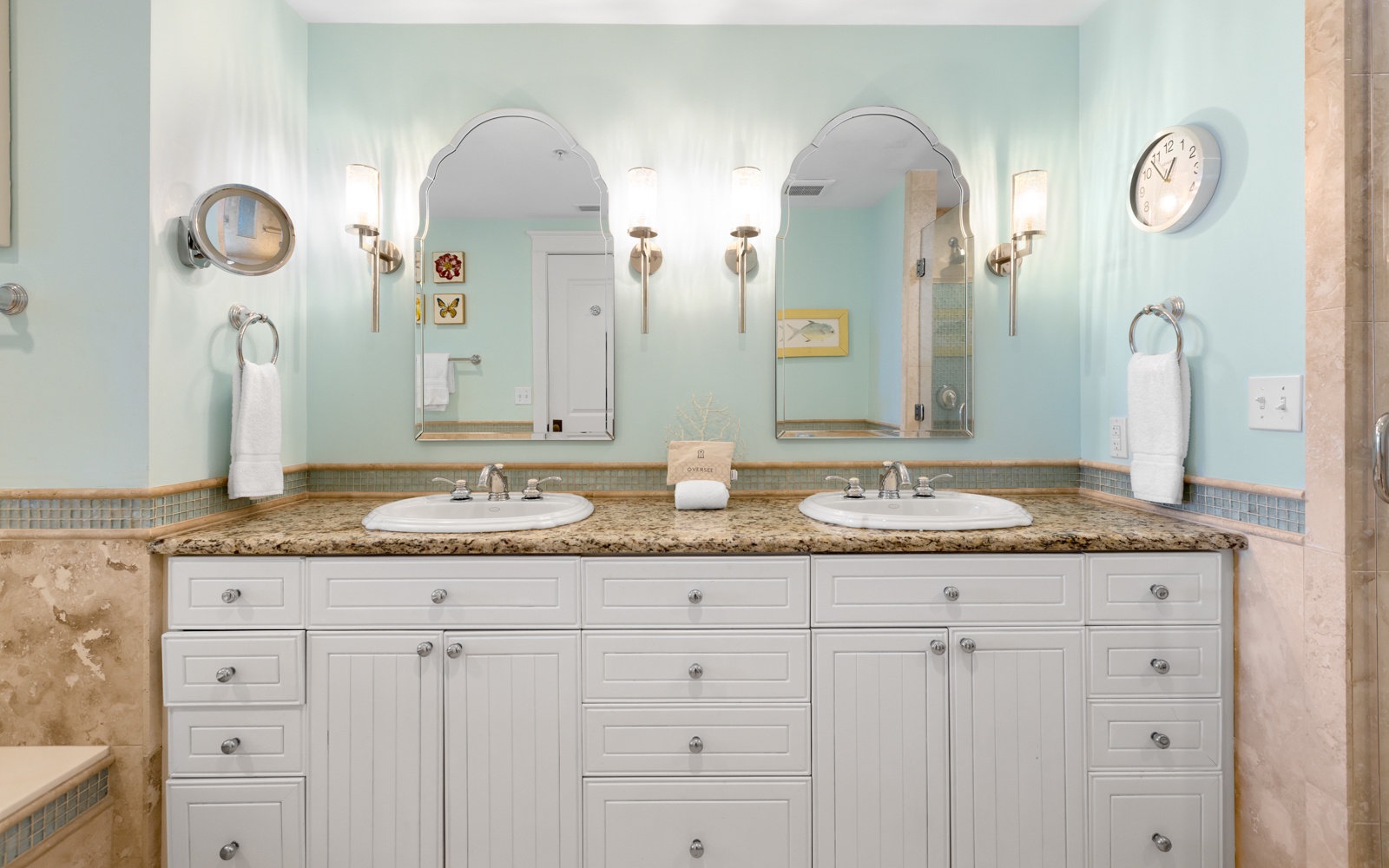Step into your private spa-like bathroom with dual vanities, granite countertops, and soothing coastal colors that make getting ready a luxurious experience.