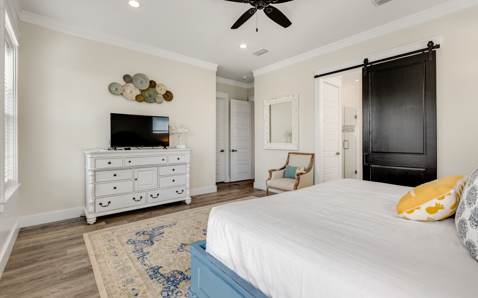 Unwind in your elegant bedroom featuring a plush bed, modern TV, and cozy seating nook where you can relax after exploring.