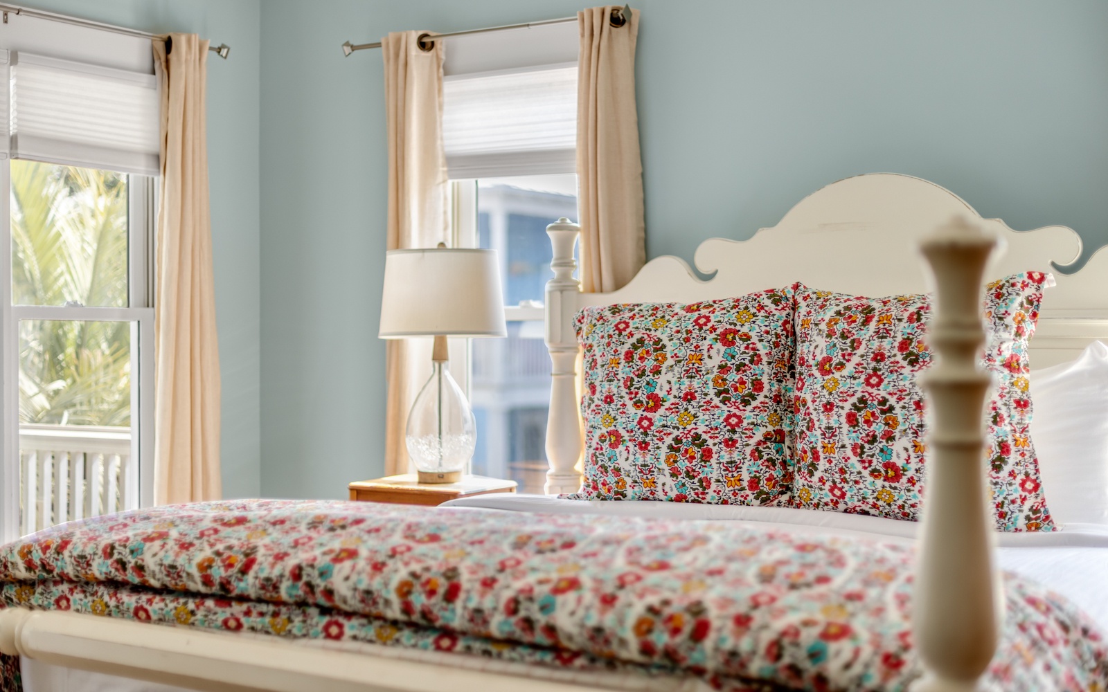 Drift off in your charming bedroom with floral linens and soft morning light filtering through cheerful curtains.
