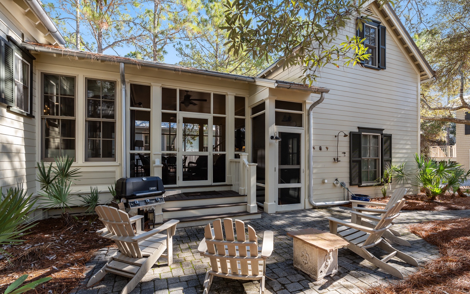 Charming coastal cottage with spacious screened porch and brick patio creates your perfect outdoor retreat.