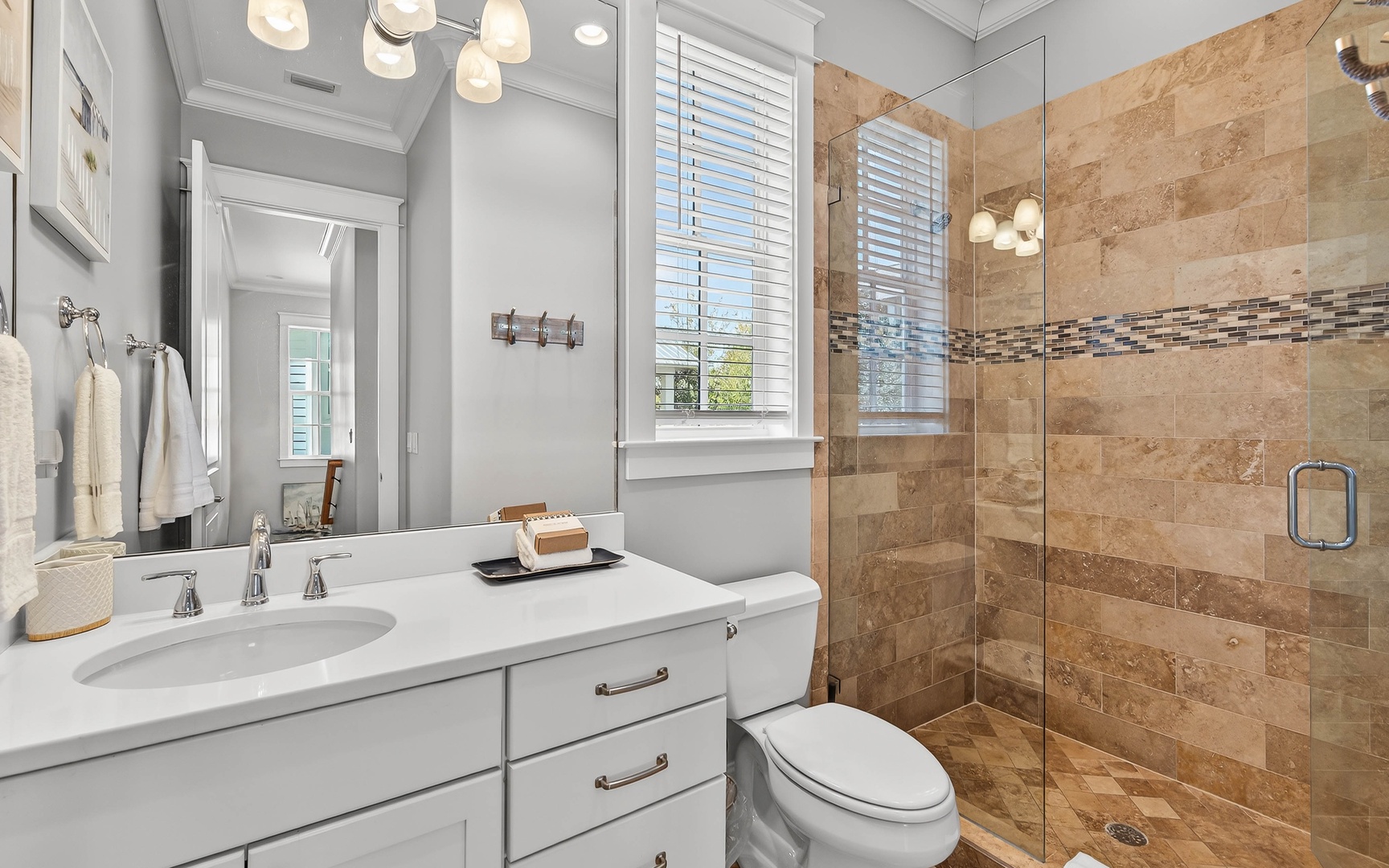 Step into your elegant bathroom featuring a luxurious glass-enclosed shower with beautiful natural stone tiles and modern pendant lighting.