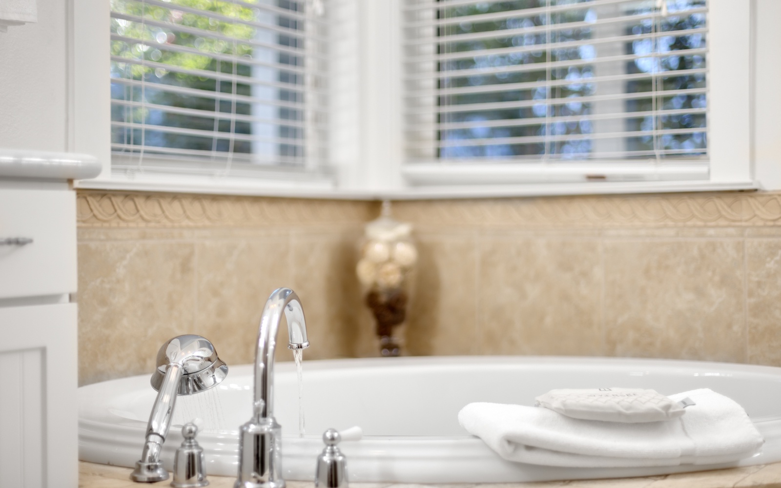 Slip into your private spa-like bathtub where warm natural light filters through blinds, creating the perfect sanctuary for relaxation.