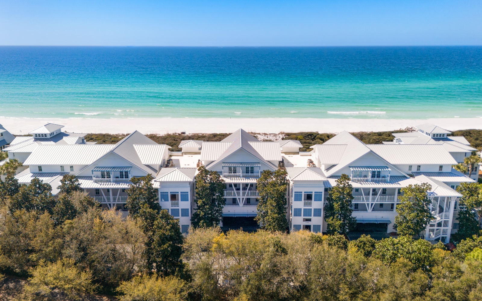 Beachfront vacation homes with pristine white sand and turquoise waters just steps away from the property.