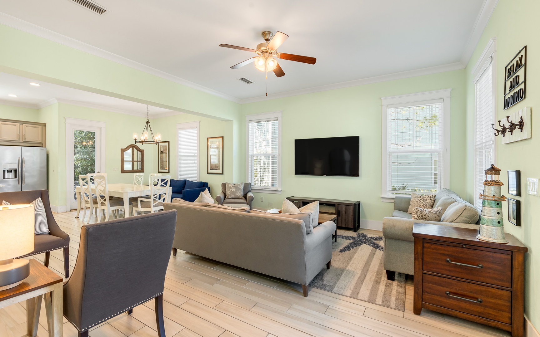 Relax in your spacious open-concept living area with comfortable seating, modern TV, and charming coastal touches throughout.