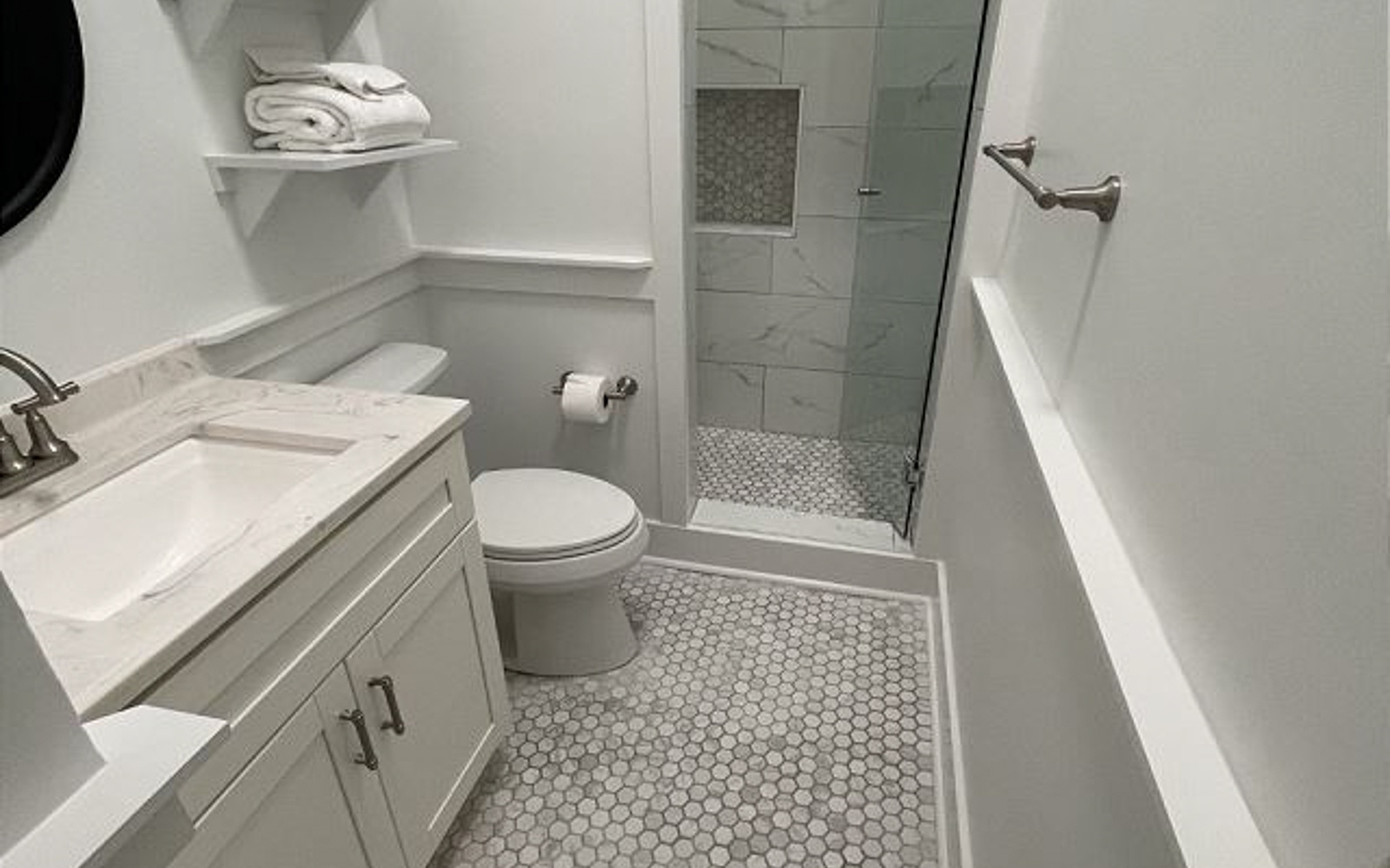 Step into your spa-like bathroom with gleaming marble tiles, spacious glass shower, and plush towels waiting for your arrival.