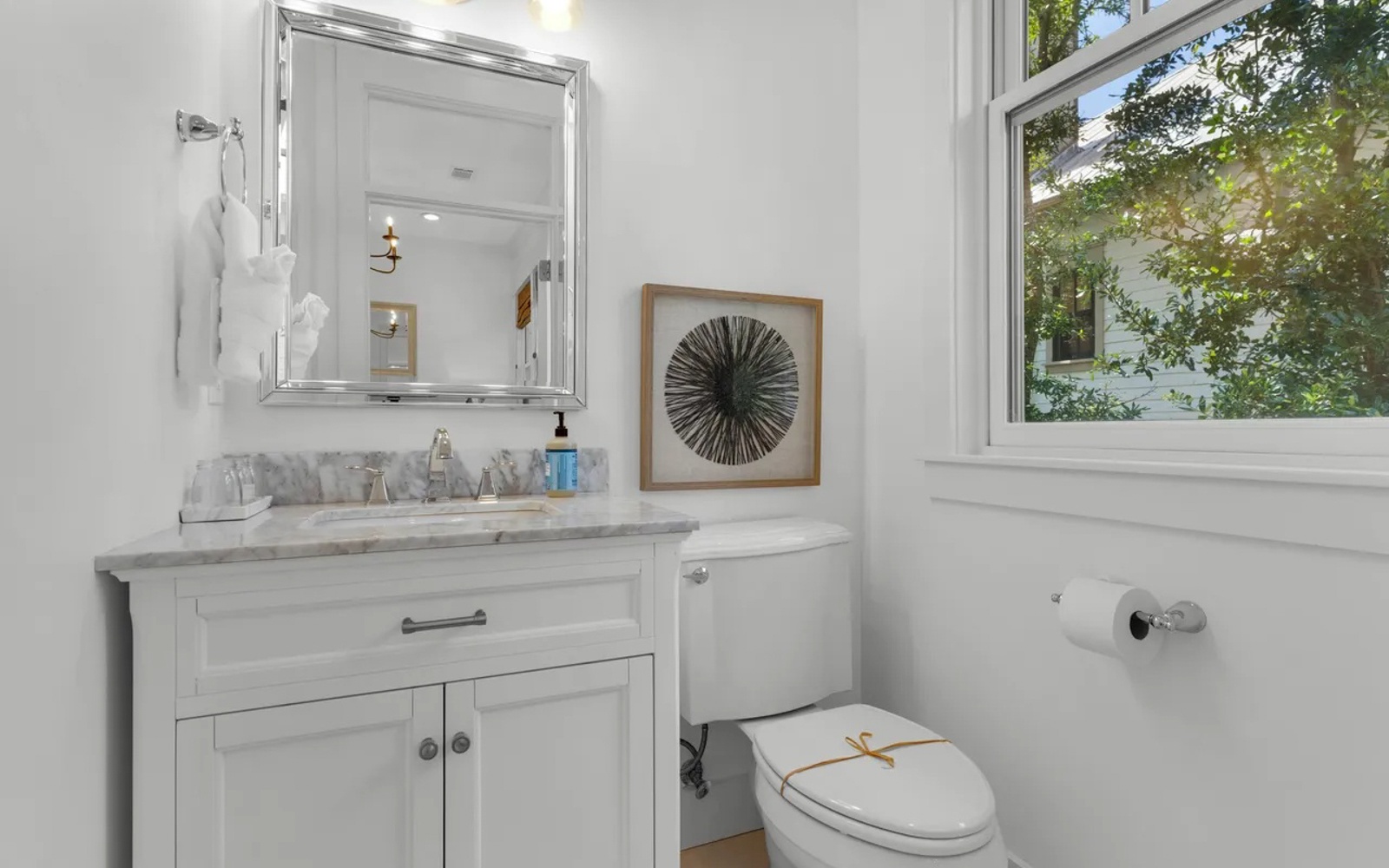 Refresh in your elegant powder room with marble countertops, crisp white cabinetry, and garden views that bring natural light into every moment.