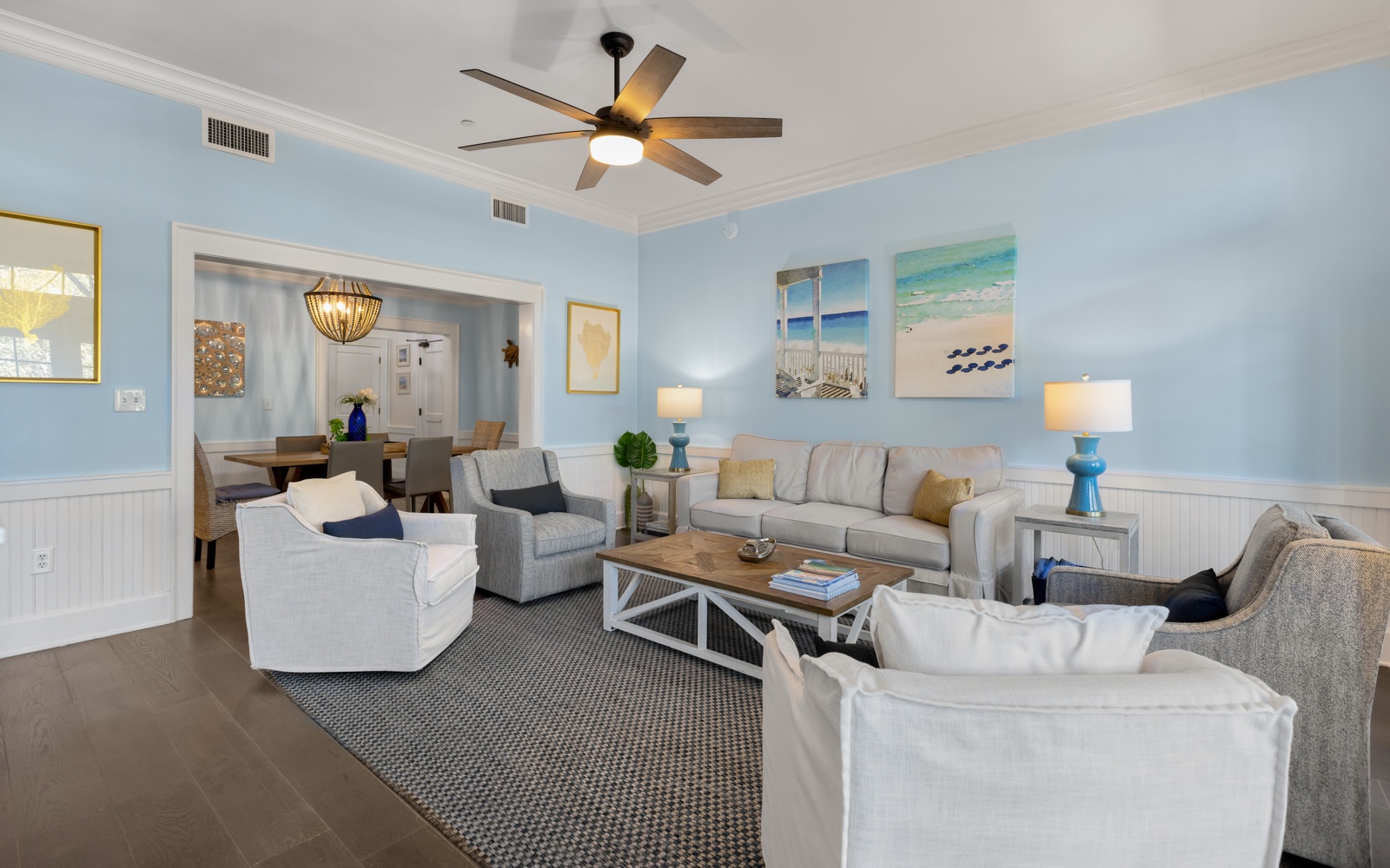 Unwind in your spacious coastal living room with plush seating and calming beach artwork that creates the perfect atmosphere for relaxation.