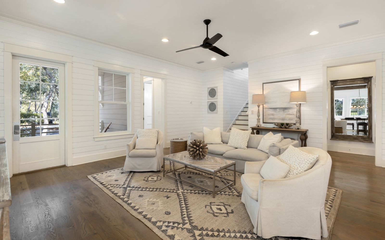 Relax in your spacious living room with plush sectional seating, stylish décor, and ceiling fan for perfect comfort.