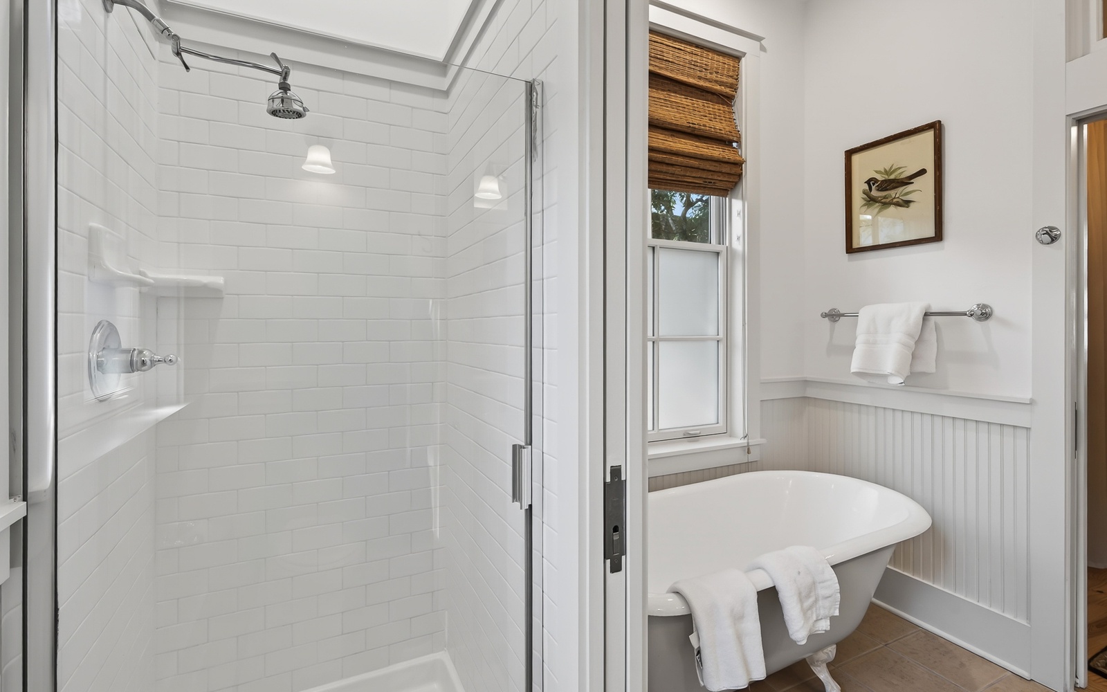 Step into your pristine bathroom sanctuary with a rainfall shower, charming subway tiles, and natural light streaming through bamboo shades.
