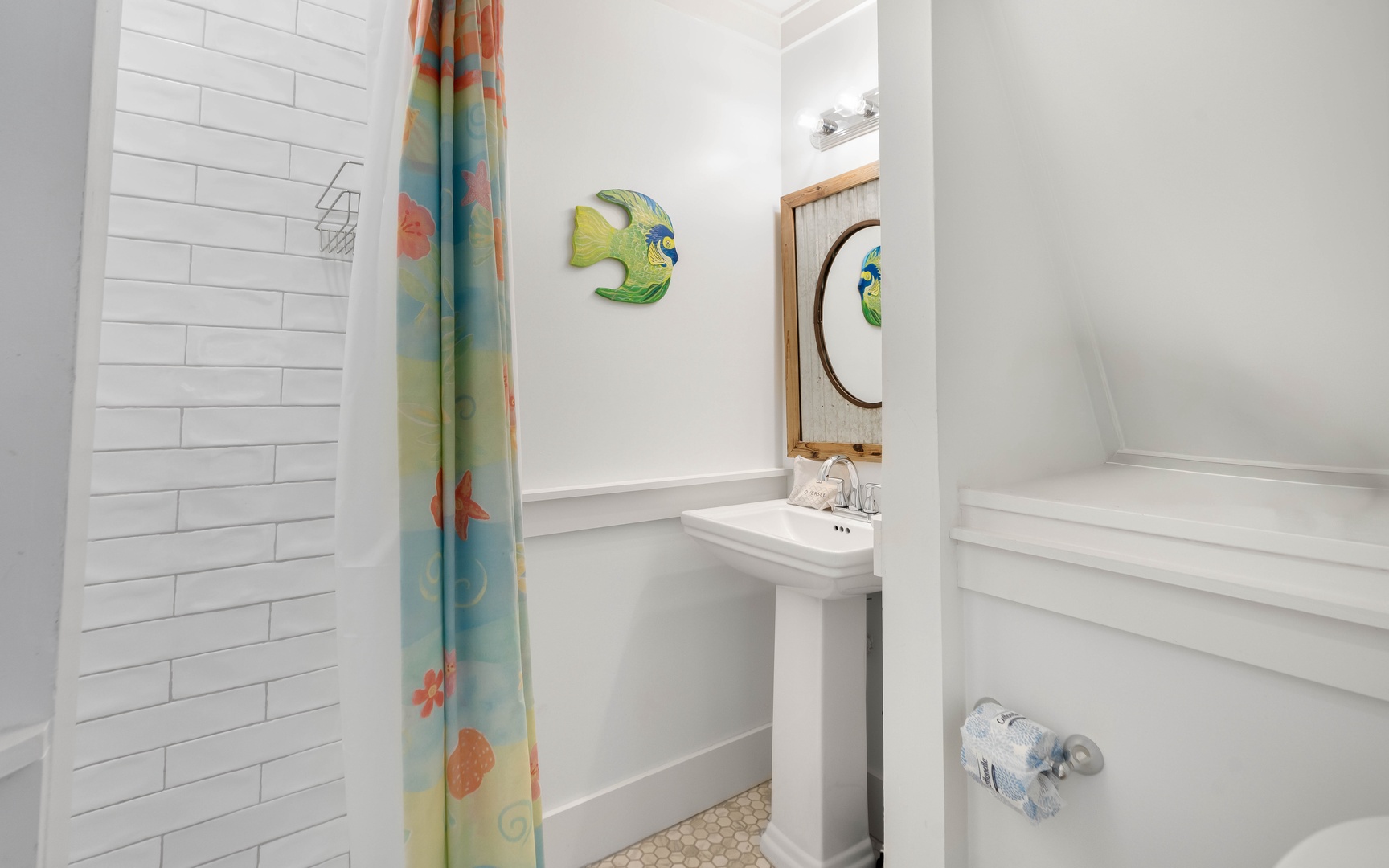 Freshen up in your bright bathroom featuring cheerful sea life decor, classic subway tile, and a relaxing soaking tub.