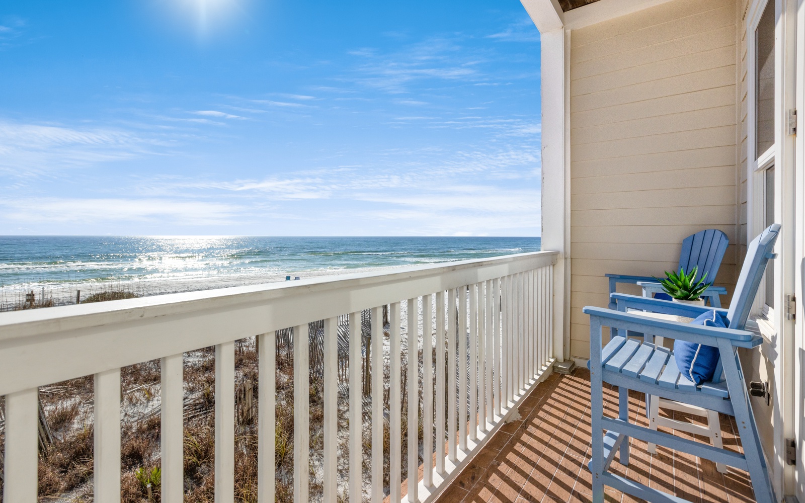Wake up to endless ocean views from your private balcony, where blue Adirondack chairs invite morning coffee moments and sunset relaxation.