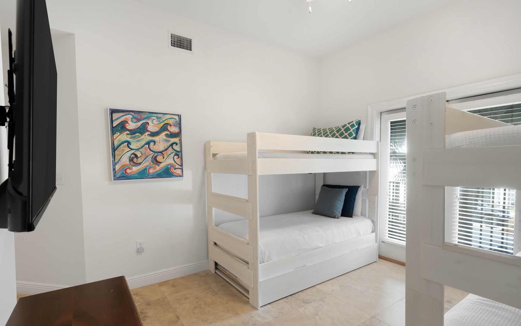 Your kids will love this bright bunk room with crisp white linens and ocean-themed art, perfect for bedtime stories.