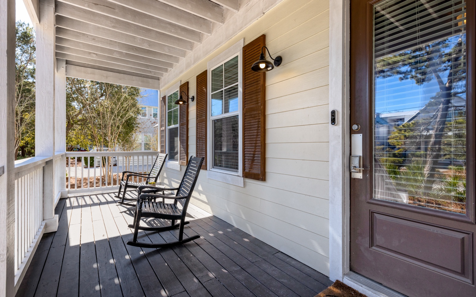 Sink into your rocking chair on this peaceful front porch, where warm wood shutters and afternoon light create the perfect spot to unwind.