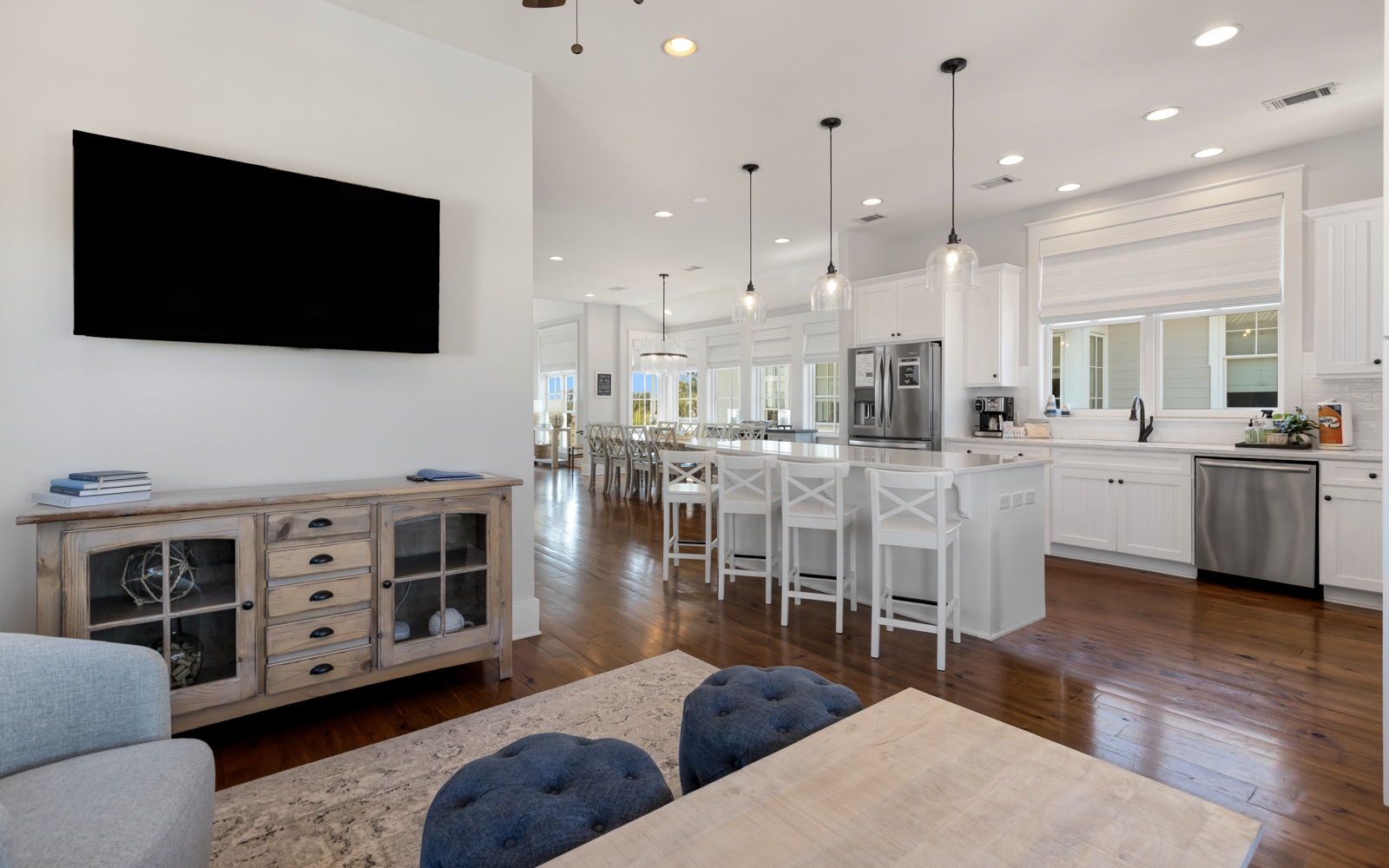 You'll love the open-concept design where living, dining, and kitchen flow seamlessly together with stylish furnishings and modern appliances for perfect group gatherings.