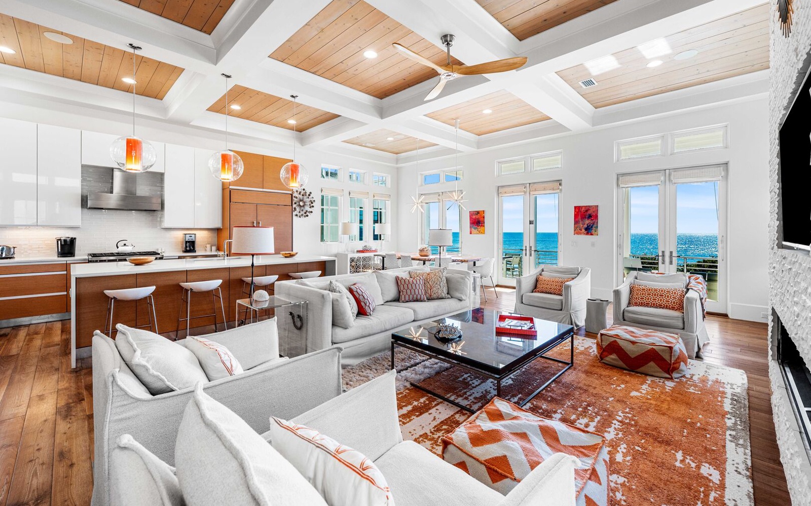Your stunning open-concept living space blends modern luxury with coastal charm, featuring soaring coffered ceilings and breathtaking ocean views.
