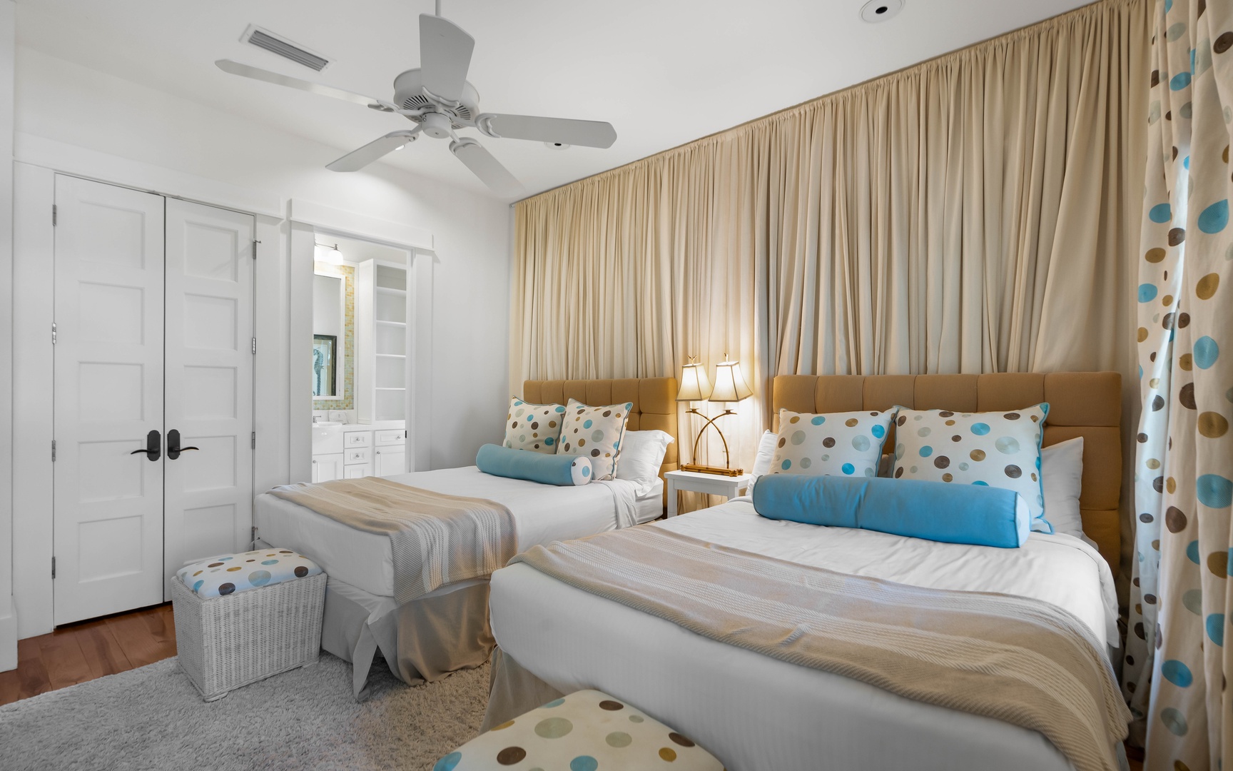 Unwind in your cheerful twin bedroom with playful polka dot accents, plush bedding, and a gentle ceiling fan for perfect comfort.