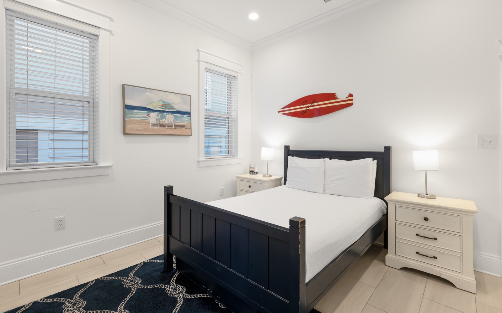 Rest easy in your coastal bedroom with crisp white linens and cheerful surf-themed decor that captures beachside charm.