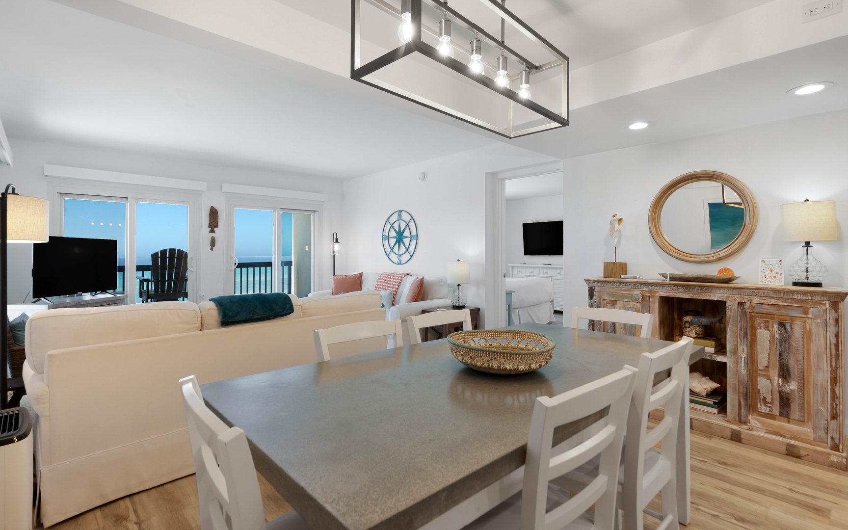 Gather around this spacious dining table where coastal charm meets modern comfort in your beachside retreat.