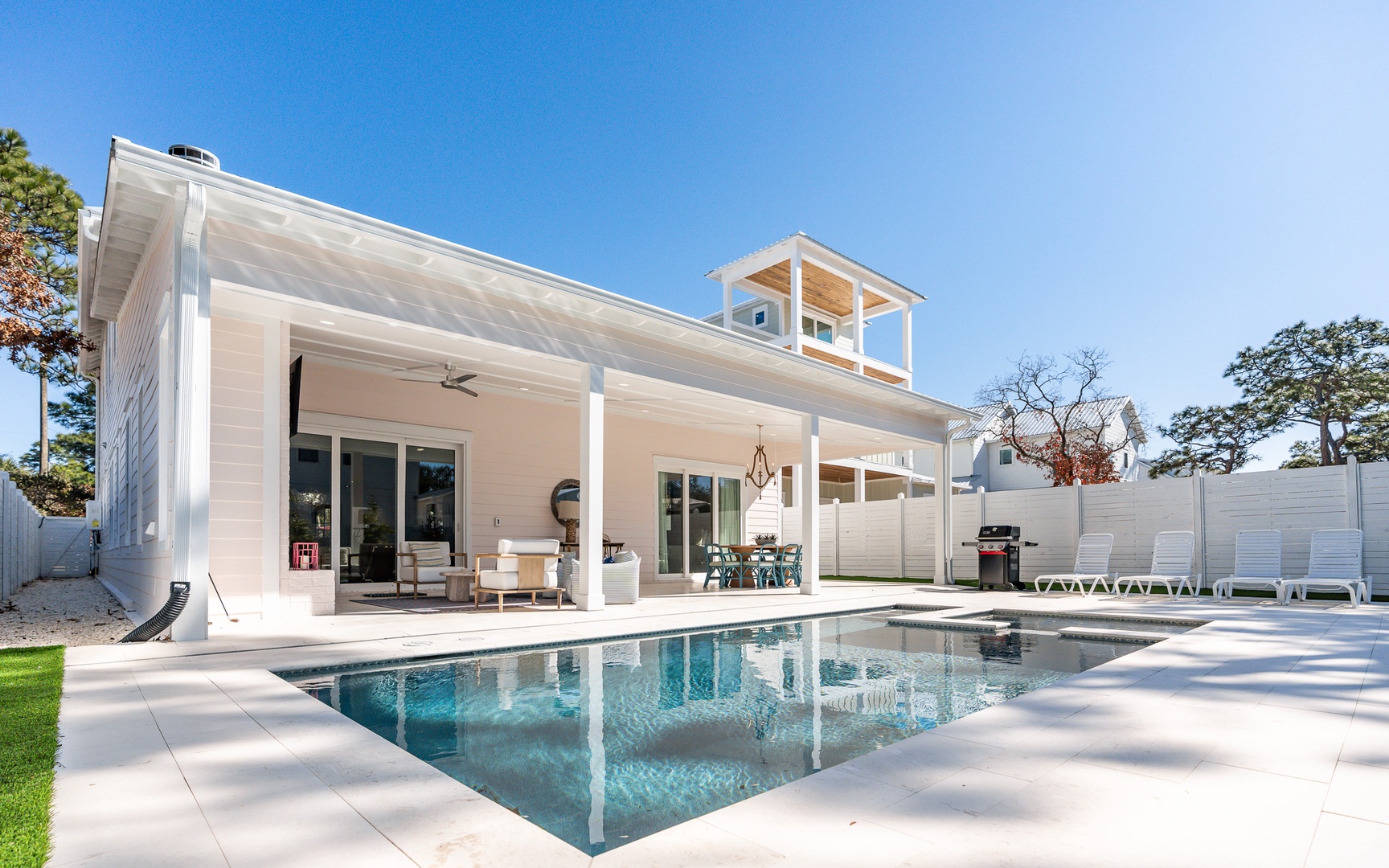 Modern coastal retreat with pristine pool and spacious covered patio for relaxing under sunny skies.