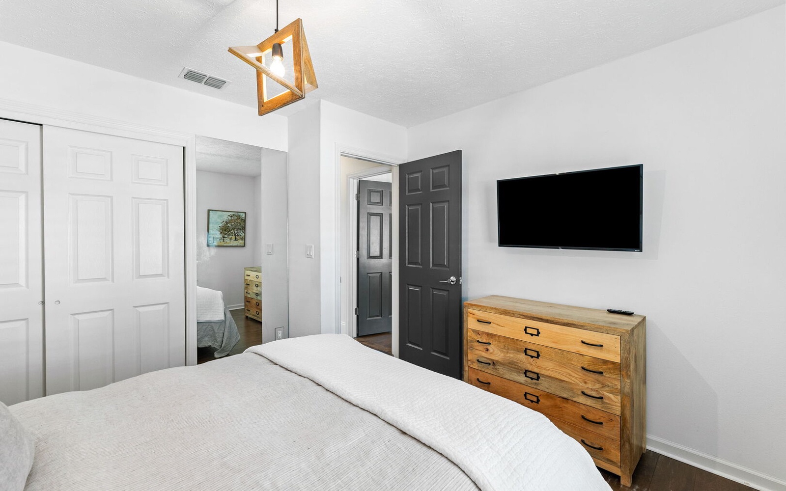 Drift off to sleep in your serene bedroom, where modern comfort meets rustic charm with handcrafted wood furnishings.