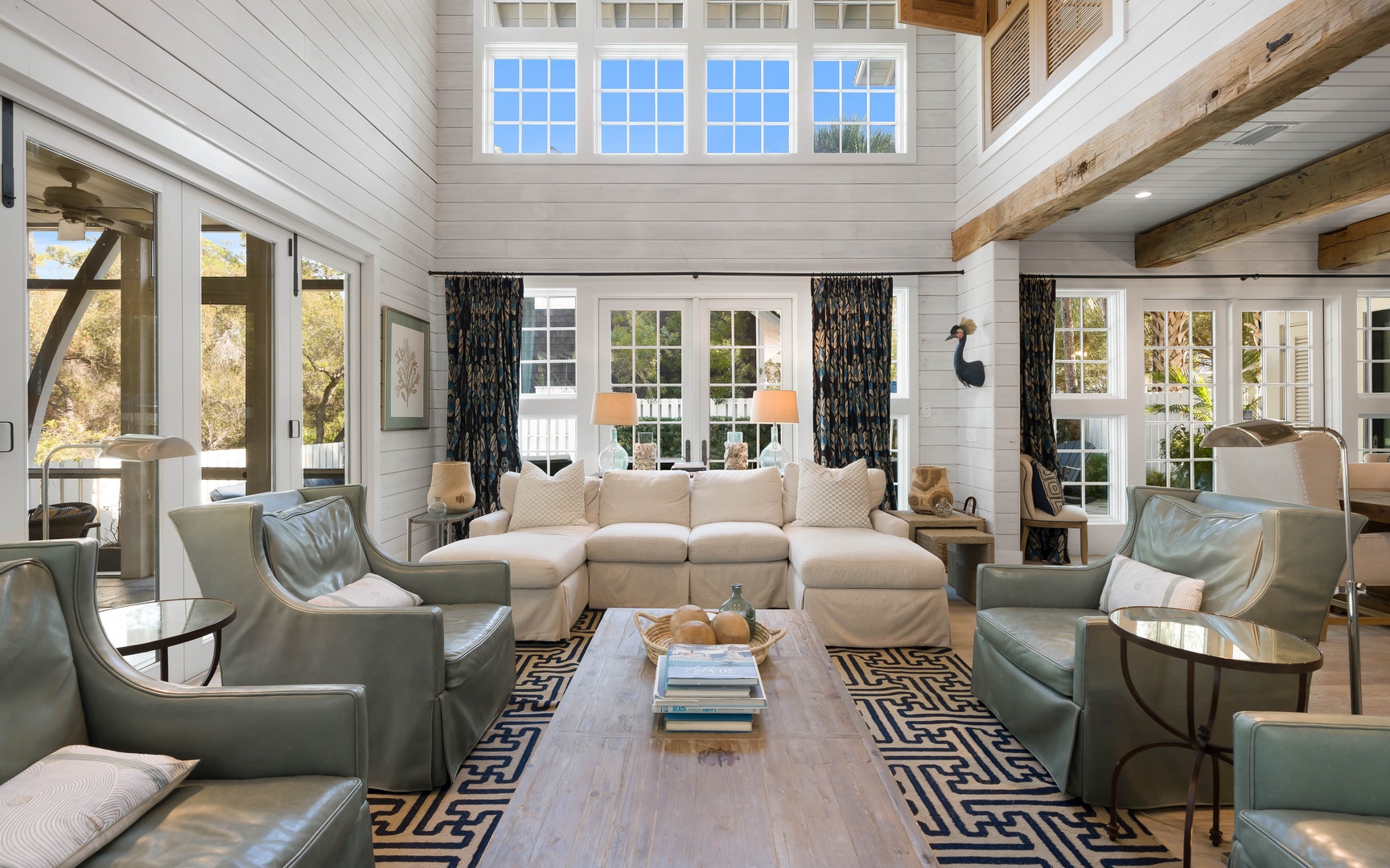 Unwind in this stunning living room where soaring ceilings, exposed beams, and soft natural light create your perfect retreat.