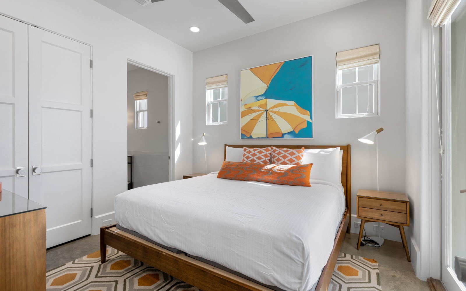 Relax in your bright bedroom featuring crisp white linens, colorful artwork, and thoughtful design touches that create a peaceful retreat.