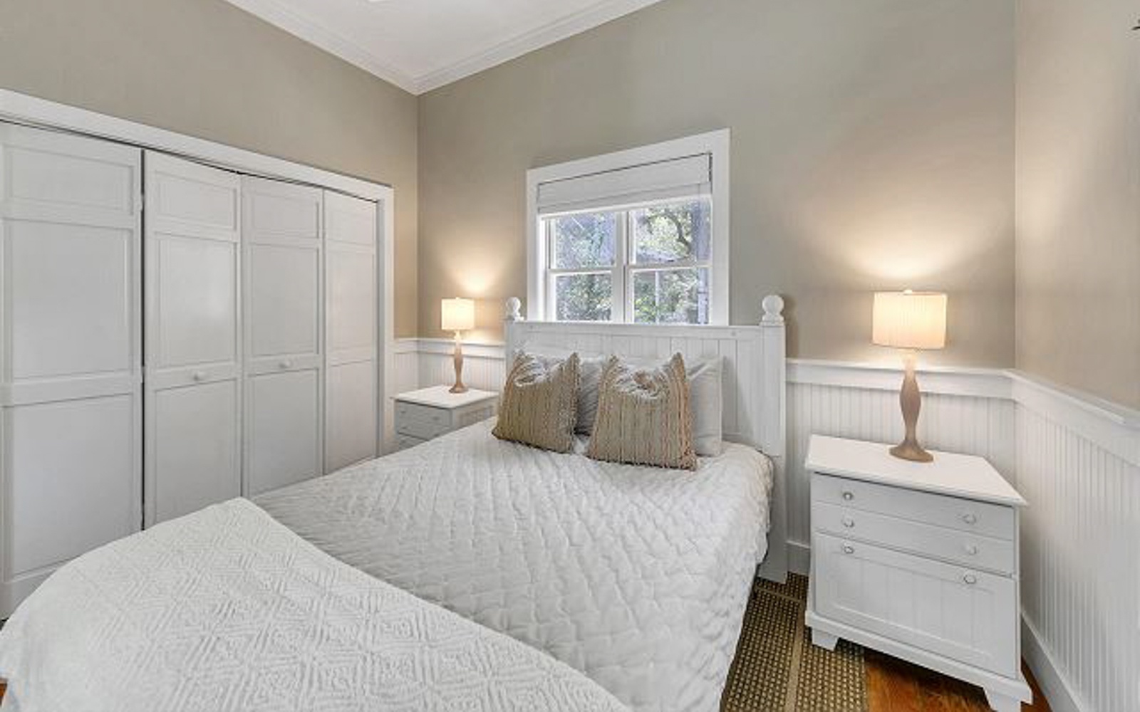 Sink into crisp white linens in your peaceful bedroom sanctuary, where soft lighting and elegant furnishings create the perfect retreat.