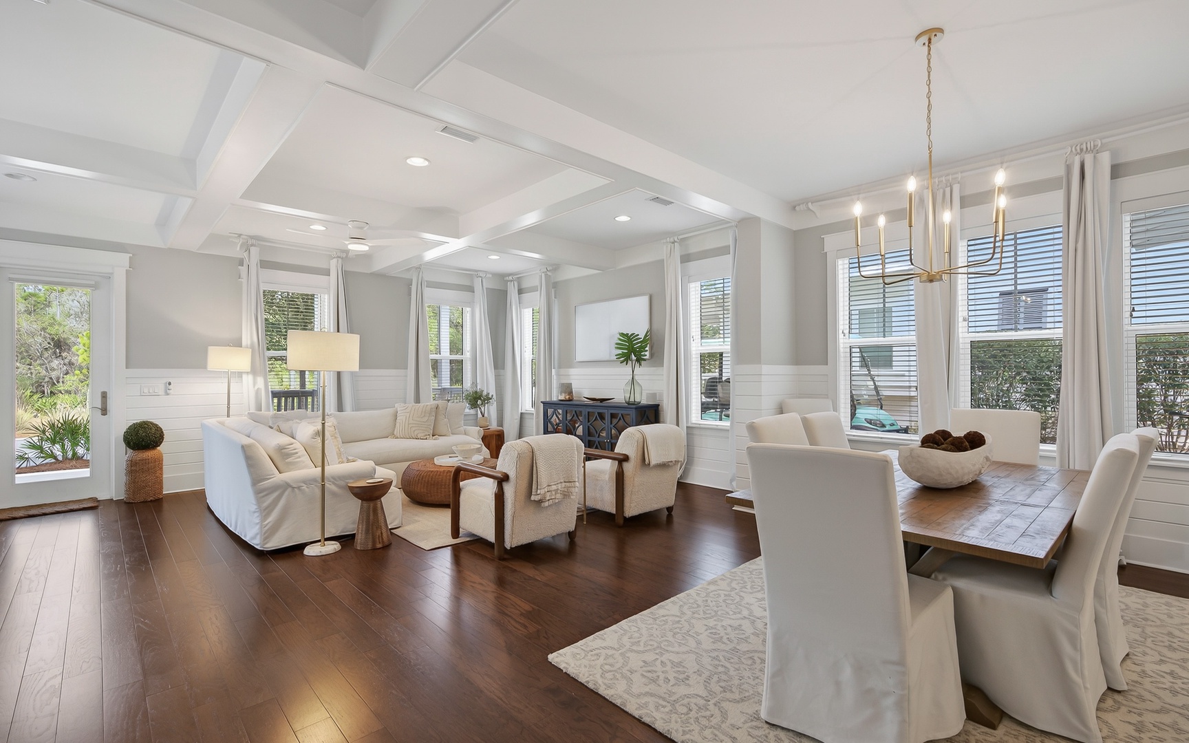 Sink into luxurious comfort in your elegant living space, where soaring coffered ceilings and warm hardwood floors create an inviting atmosphere for relaxation and memorable gatherings.