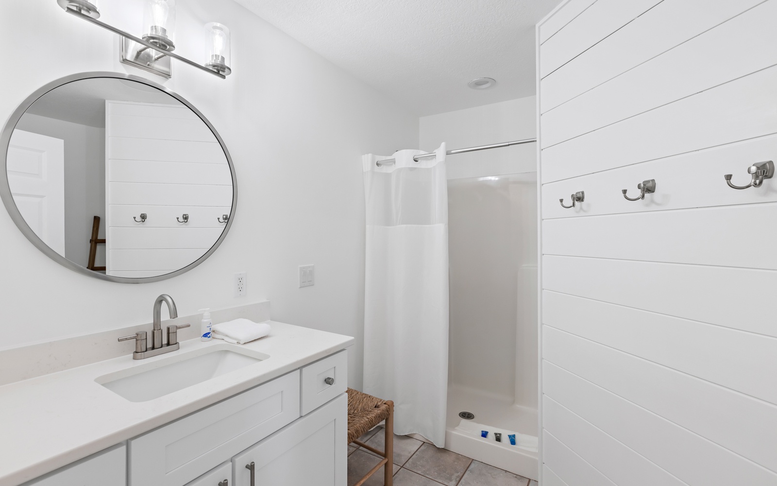 Step into your serene bathroom sanctuary with clean white shiplap, a spacious walk-in shower, and thoughtful touches that make freshening up a pleasure.