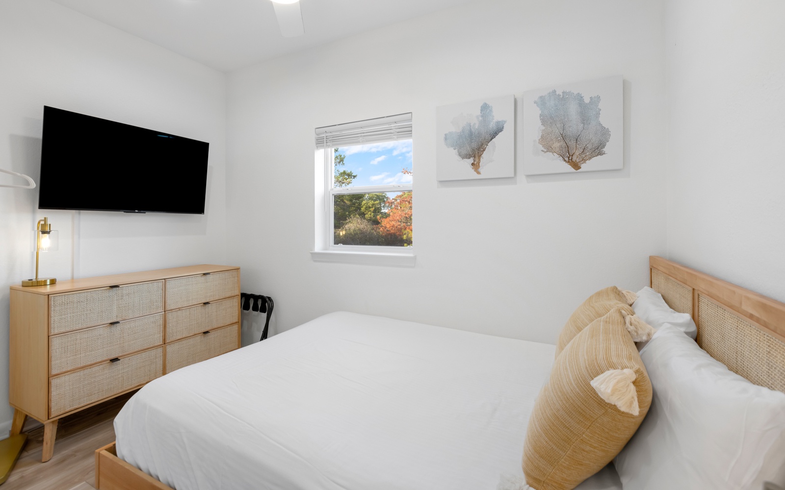 Wake up to gorgeous autumn views from your cozy bedroom, featuring warm wood accents, crisp white linens, and modern amenities for ultimate comfort.