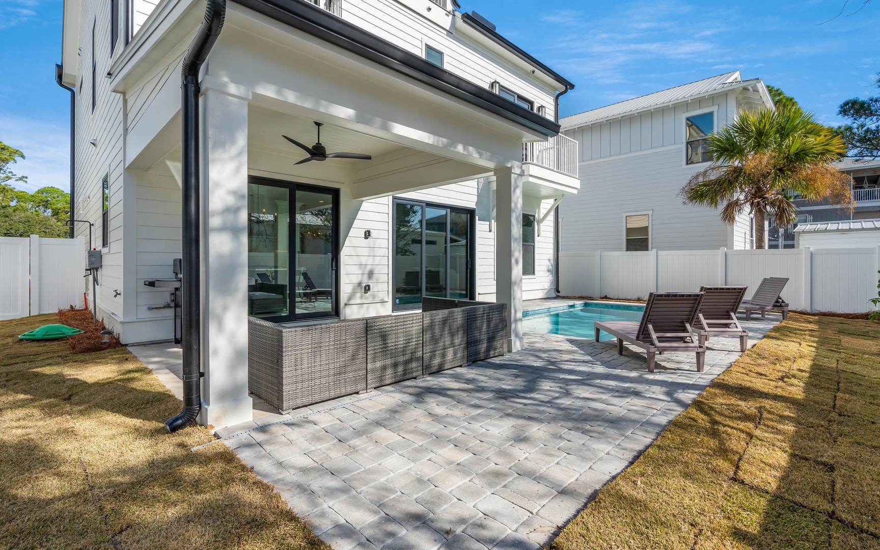 Your private covered patio features wicker seating and a sparkling pool, perfect for morning coffee or evening relaxation.