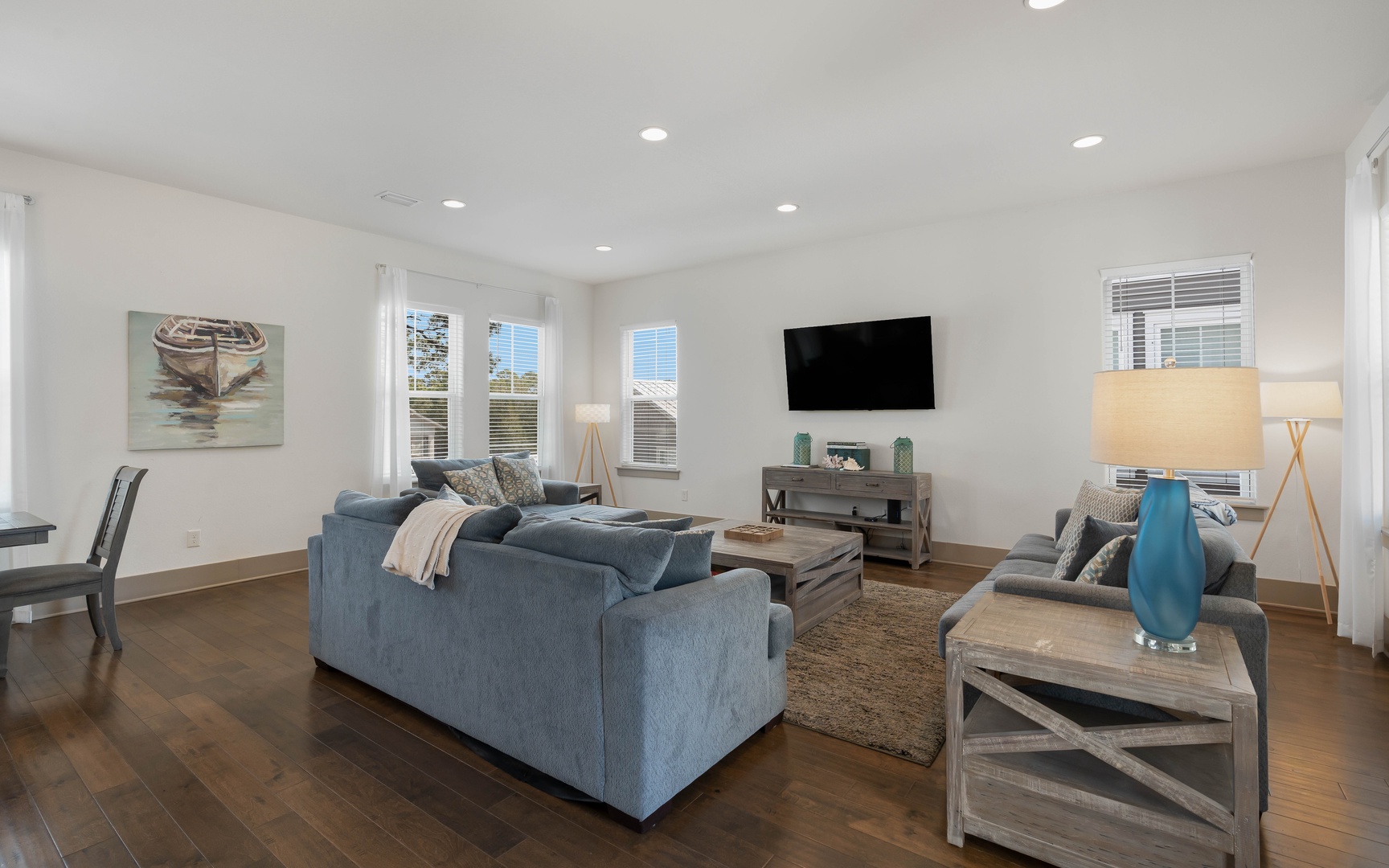 Sink into plush blue sofas and unwind in your bright, modern living space with entertainment ready.