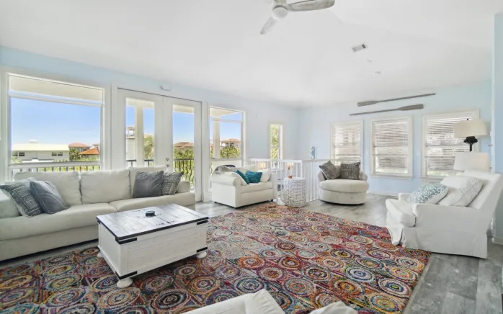 Sink into plush white sofas in your bright living room, where colorful rugs warm polished floors and ocean breezes flow through French doors.