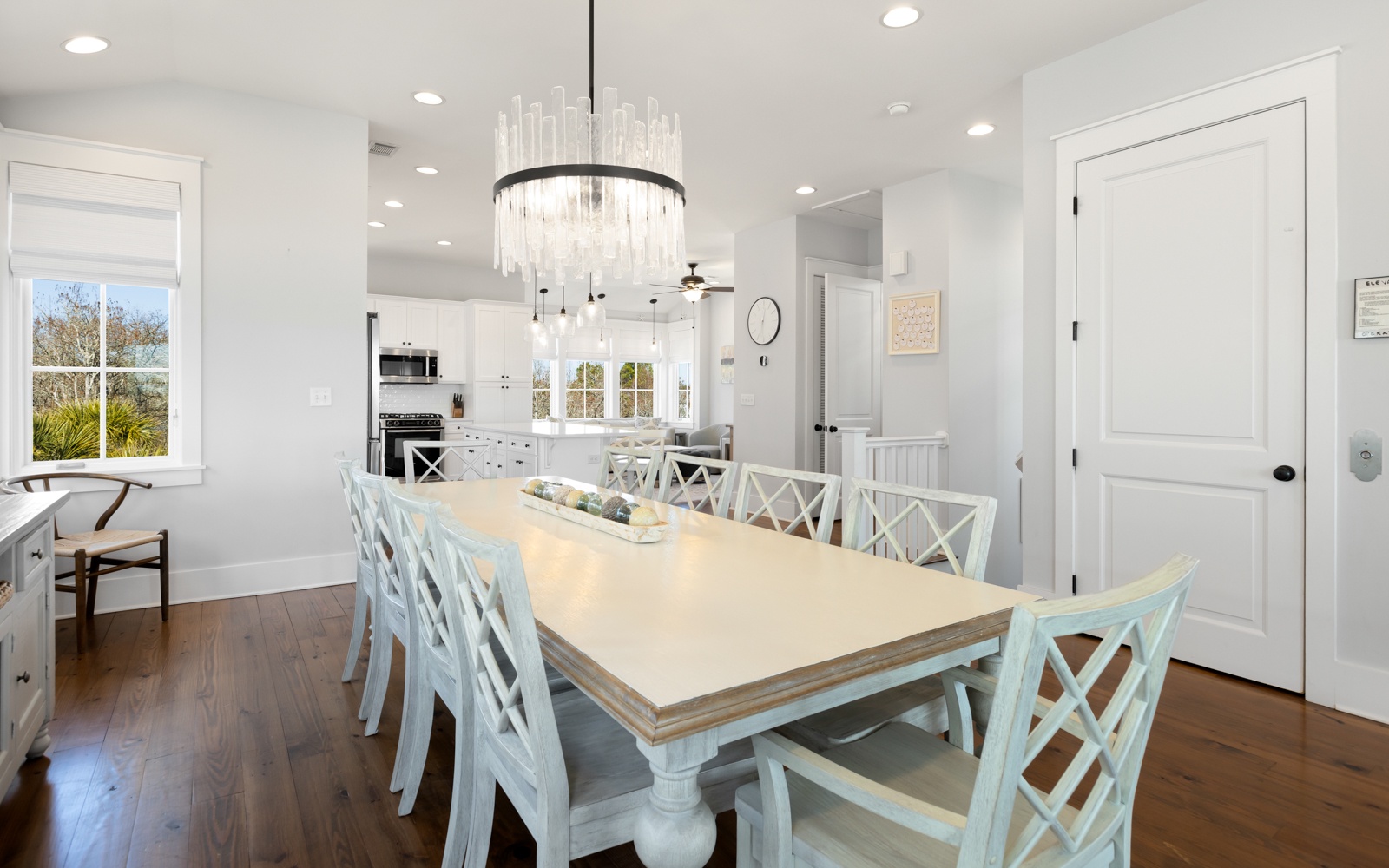 Gather around your elegant dining table for memorable meals beneath a stunning chandelier in this bright, open space.