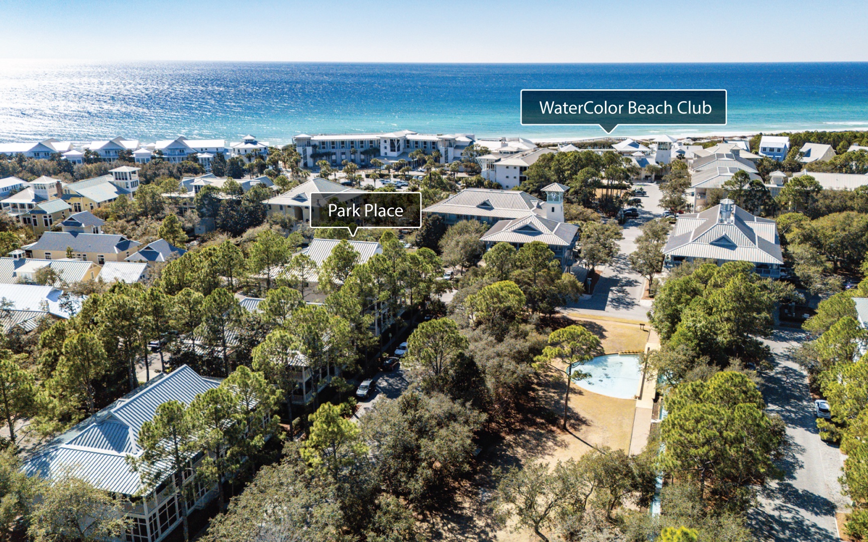 Aerial view of beachfront community with pristine white sand beaches and turquoise waters nearby.
