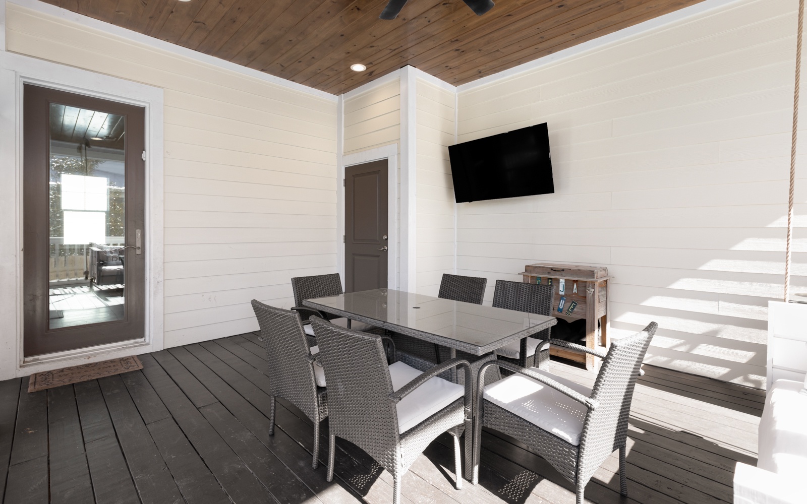 Your private covered patio offers comfortable dining with modern furnishings and entertainment, perfect for enjoying meals outdoors year-round.